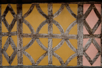 Timber frame pattern with colorful painted wattle and daub in an historic Tudor building Faversham Kent England.