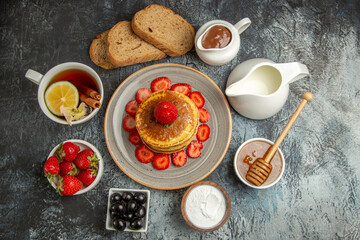 top view yummy pancakes with tea and fruits on light background fruits cake sweet