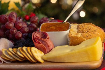 Obraz na płótnie Canvas Board with Grape, Cookie, Jam, Bread, Ham, Candle, Pine Cone, Cheese to eat at the Christmas picnic