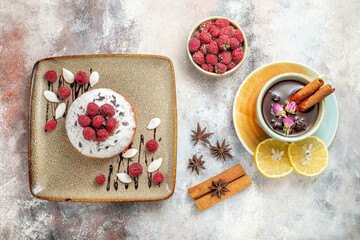 Freshly baked cake with raspberries a cup of black tea with lemon and cinnamon lime stock image