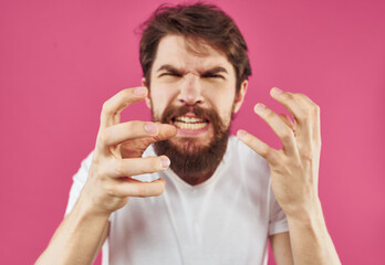 Man on pink background stress irritability aggression gesticulating with hands cropped view