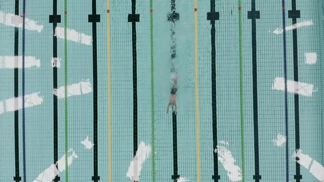 A professionnal swimmer swimming in a olympian swimming pool