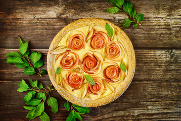 Fototapeta na wymiar Top view of apple pie with rose shape apple decorated and green leaves.