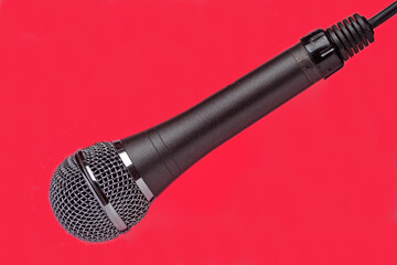 Fragment of a studio microphone on a red background close-up