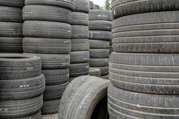 Stack of old used car tires on the ground, selective focus