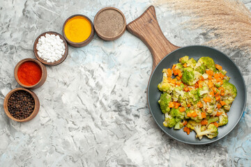 Horizontal view of healthy vegetable salad different spices on white background
