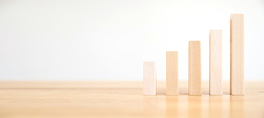 Wooden block as graph step up staircase on wood desk. Ladder career path concept for business...