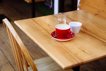 Dirty coffee cups, cappuccino and a glass of water stand on a wooden table. Coffee break. Delight in taste and aroma.