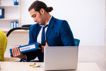 Young male employee looking after kid at workplace
