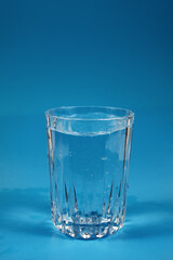 Drinking clean water in a glass on a blue background