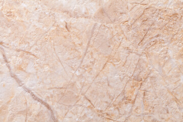 Texture of decorative beige plaster imitating the old peeling stone wall.