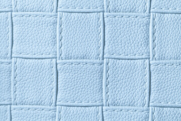 Fototapeta premium Texture of light blue leather background with square pattern and stitch, macro.