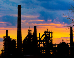 Pipes in a factory at sunset.