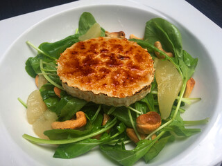 Grilled and caramelized goat cheese served with arugula salad, sauteed pears and cashew nuts