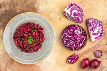 Fototapeta na wymiar top view fresh vegetable salad on a ceramic plate made of a bowl of chopped red cabbage and red onions on a wooden background
