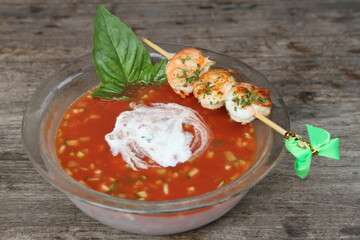 Gazpachio. A Spanish cold soup made of raw, blended vegetables. Served with a shrimp skewer