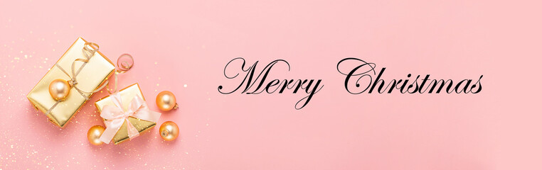 Festive boxes with satin ribbon bow golden toy balls a pastel pink background