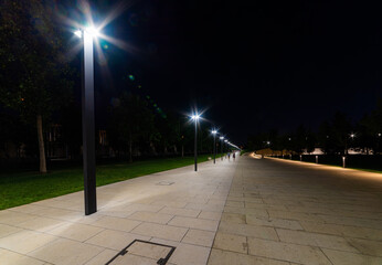 Maple alley in French garden in public landscape city park Krasnodar or Galitsky park . Wooden circular brown benches around maple trees