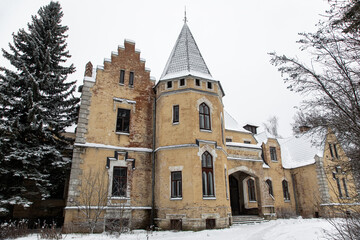 Fototapeta na wymiar Beautiful old abandoned castle. Snowy winter day. Ancient Gothic architecture.
