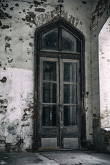 A beautiful door in an old abandoned manor house. Gothic door and architecture.