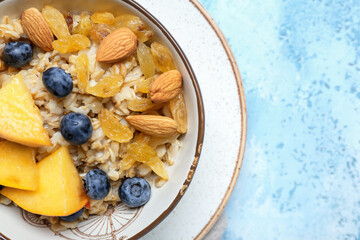 Bowl with tasty sweet oatmeal on table
