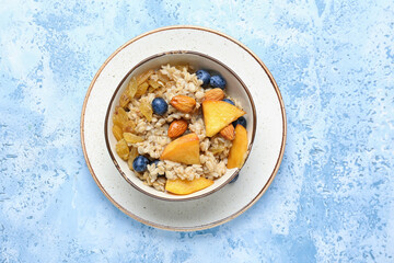 Bowl with tasty sweet oatmeal on table
