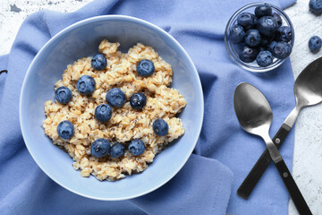 Bowl with tasty sweet oatmeal on table