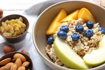 Bowl with tasty sweet oatmeal, closeup