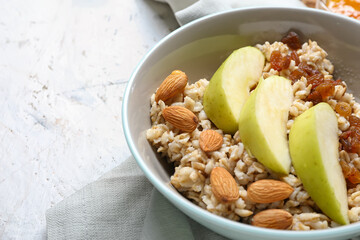 Bowl with tasty sweet oatmeal, closeup