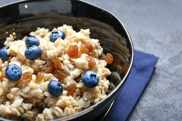 Bowl with tasty sweet oatmeal, closeup
