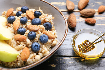 Bowl with tasty sweet oatmeal, closeup