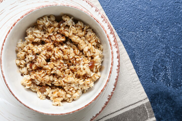 Bowl with tasty sweet oatmeal on table