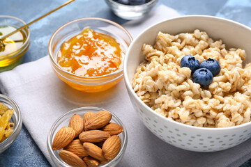 Bowl with tasty sweet oatmeal on table