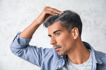 Man with graying hair on light background