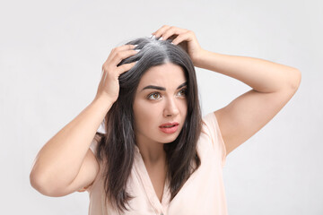 Obraz premium Stressed woman with graying hair on light background