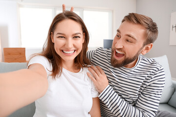 Young couple taking selfie at home