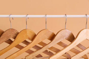 Rack with clothes hangers on color background, closeup