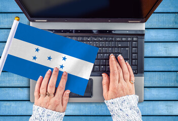 woman hands and flag of Honduras on computer, laptop keyboard 