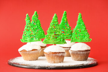Tasty Christmas cupcakes on color background