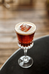 Espresso martini cocktail with vodka and coffee liqueur in a beautiful glass at the bar