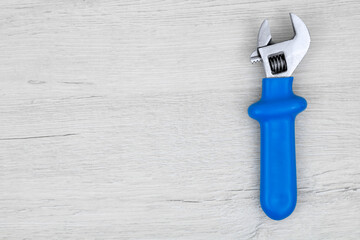 Wrench on a background of bleached wood. Seamless background from adjustable metal wrench. 
