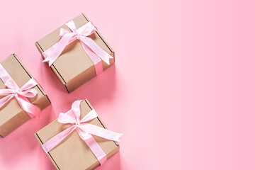 Gift box with pink ribbon bow on pink background