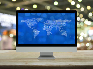 Start up business flat icon with global words world map on desktop modern computer monitor screen on wooden table over blur light and shadow of shopping mall, Happy new year 2021 global business start