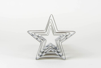 Metal forms for cookies in the shape of a star on a white background in a row.