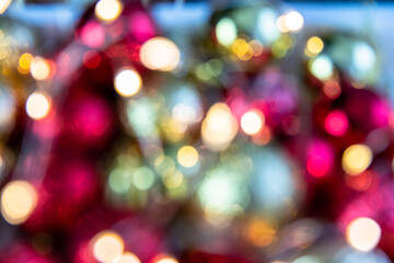 Obraz premium Gold and red bokeh abstract background with defocused lights and Christmas balls.