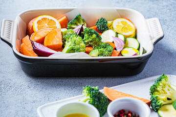 Raw chopped vegetables - sweet potatoes, zucchini, broccoli and carrots in baking dish. Cooking vegetables for baking in oven. Cooking healthy food concept.