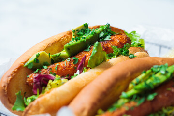 Vegan carrot hot dog with salad and avocado. Alternative fast food. Healthy food concept.