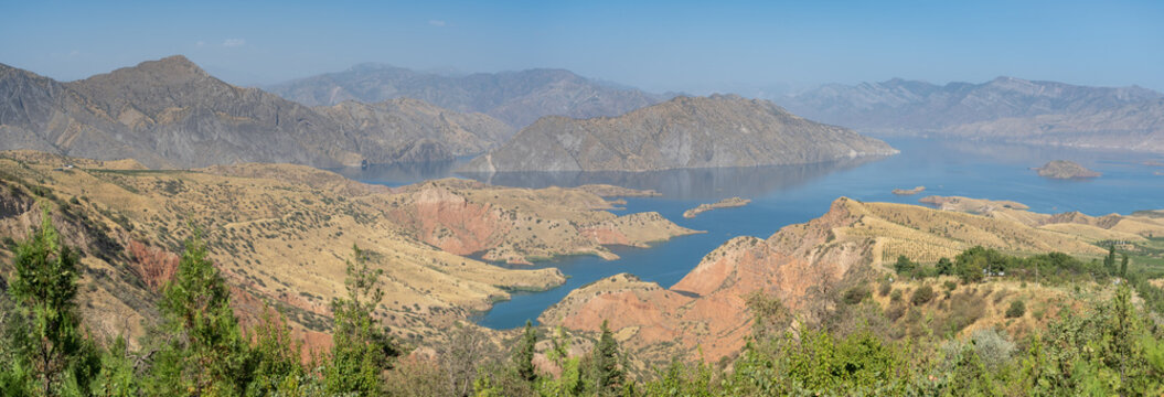 Landscape panorama of Nurek dam lake second highest in world between Dushanbe and Khatlon regions in Tajikistan with trees in the foreground