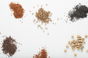 Cabbage, watercress, coriander, basil, nasturtium seeds on white textured background. Top view.
