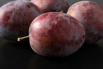 fresh plums in a black plate